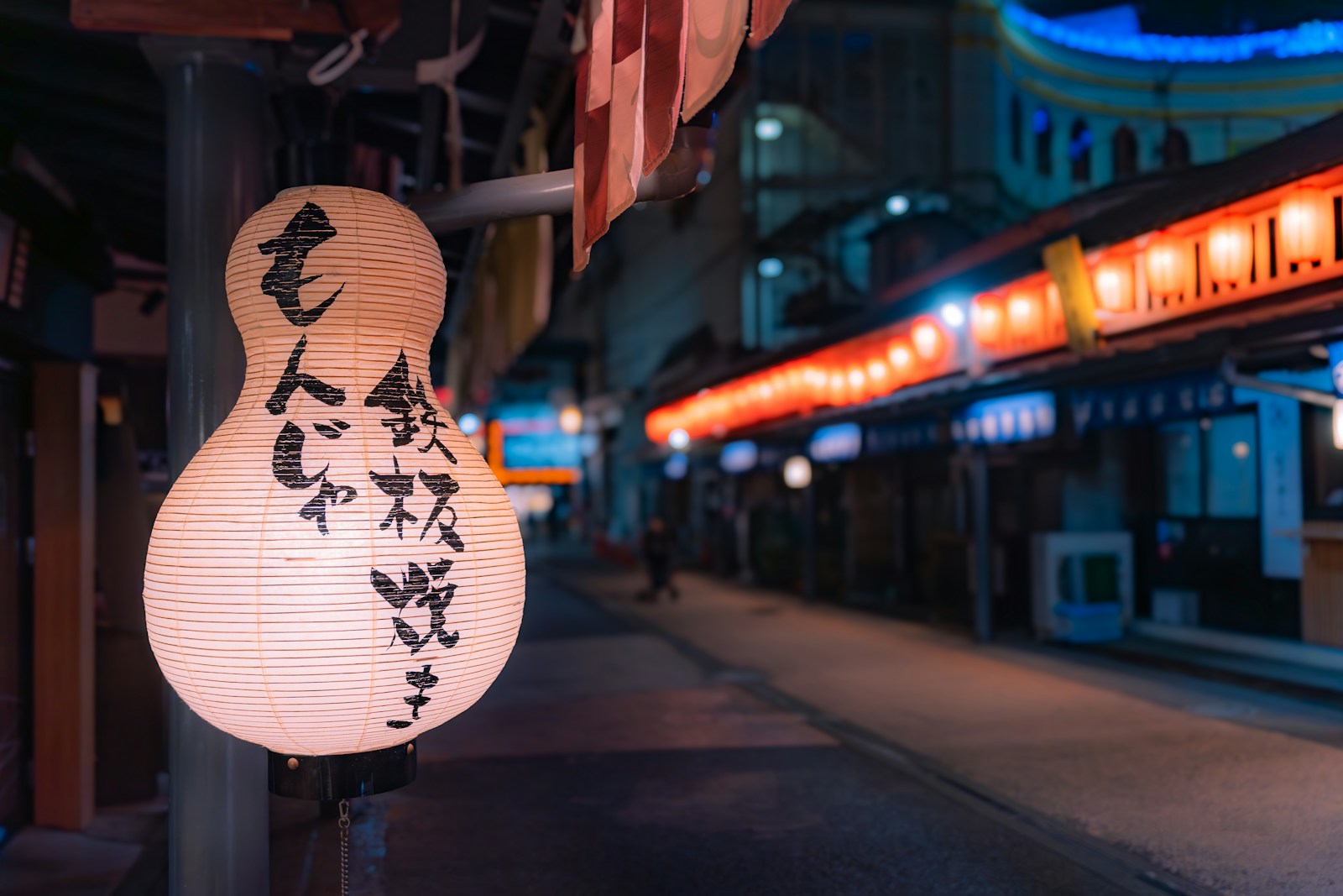 A street sign with a lit up building in the background