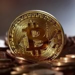 Close-up of a digital cryptocurrency Bitcoin coin placed on a pile of coins.