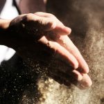 person clapping its hand with sand