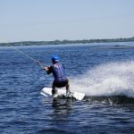 man in blue and white wet suit riding white surfboard during daytime